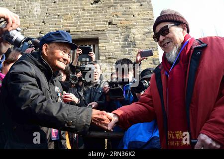 (150408) -- TAI ERZHUANG, 8 avril 2015 -- les vétérans Shao Jingdou et Jiang Siyu, âgés respectivement de 101 et 102 ans, serrez la main devant un mur touché par des balles dans le parc des reliques de la bataille de Tai erzhuang lors d'une cérémonie pour célébrer le 77e anniversaire de la victoire de la bataille à Tai erzhuang, dans la province du Shandong de l'est de la Chine, le 8 avril 2015. La bataille de Tai erzhuang, une bataille de la guerre anti-japonaise (1937-1845) en 1938 entre les armées chinoise et japonaise, a été la première victoire chinoise majeure de la guerre. Il humiliait l'armée japonaise et sa réputation de force invincible. Banque D'Images