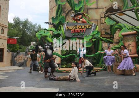 (150408) -- SINGAPOUR, le 8 avril 2015 -- des acteurs se produisent devant l'entrée des montagnes russes Puss in Boots Giant Journey aux Universal Studios Singapore à Singapour, le 8 avril 2015. Puss in Boots Giant Journey , un programme de montagnes russes suspendues, a été lancé mercredi à Universal Studios Singapore. Puss in Boots , qui est apparu à l'origine dans la franchise Shrek, est devenu célèbre en octobre 2011 avec son premier film à succès. Le lancement des montagnes russes suspendues à thème souligne les célébrations du cinquième anniversaire du parc à thème. SINGAPORE-UNIVERSAL STUDIOS SINGAPORE- PUSS Banque D'Images