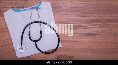 Stéthoscope, allongé sur une blouse médicale. Journée du docteur. Gros plan, pas de gens. Pose à plat Banque D'Images