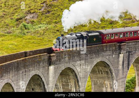 Célèbre entraînement à vapeur passant au-dessus d'un viaduc courbe à Glenfinnan dans les Highlands écossais Banque D'Images