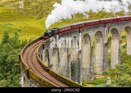 Célèbre entraînement à vapeur passant au-dessus d'un viaduc courbe à Glenfinnan dans les Highlands écossais Banque D'Images