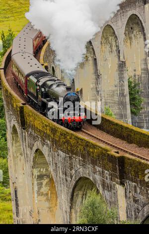 Célèbre entraînement à vapeur passant au-dessus d'un viaduc courbe à Glenfinnan dans les Highlands écossais Banque D'Images