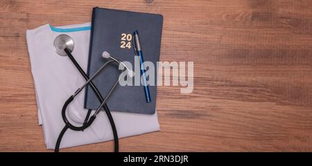 Stylo, stéthoscope, allongé sur une robe médicale. Journée du docteur. Gros plan, pas de gens. Pose à plat Banque D'Images