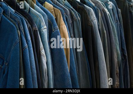 Row Of Vintage Denim Shirts Hanging On A Rail For Sale, England UK Stock Photo