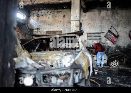 (150417) -- JOHANNESBURG, le 17 avril 2015 -- Un homme vérifie un véhicule brûlé dans un garage appartenant à des Nigérians à Johannesburg Town, en Afrique du Sud, le 17 avril 2015. Vendredi, la police sud-africaine a tiré des balles en caoutchouc pour disperser les émeutiers dans le centre de Johannesburg, un nouveau foyer de violence xénophobe. La vague actuelle de violence xénophobe touche principalement Durban et Johannesburg. Selon les chiffres officiels, cinq personnes ont été tuées et des milliers d'immigrants déplacés. (djj) AFRIQUE DU SUD-JOHANNESBURG-ATTAQUE XÉNOPHOBE ZhaixJianlan PUBLICATIONxNOTxINxCHN Johannesburg avril 17 2015 a Man Checks Banque D'Images