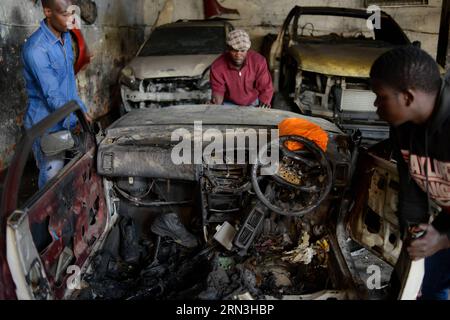 (150417) -- JOHANNESBURG, le 17 avril 2015 -- des gens déplacent un véhicule brûlé dans un garage appartenant à des Nigérians à Johannesburg Town, en Afrique du Sud, le 17 avril 2015. Vendredi, la police sud-africaine a tiré des balles en caoutchouc pour disperser les émeutiers dans le centre de Johannesburg, un nouveau foyer de violence xénophobe. La vague actuelle de violence xénophobe touche principalement Durban et Johannesburg. Selon les chiffres officiels, cinq personnes ont été tuées et des milliers d'immigrants déplacés. (djj) AFRIQUE DU SUD-JOHANNESBURG-ATTAQUE XÉNOPHOBE ZhaixJianlan PUBLICATIONxNOTxINxCHN Johannesburg avril 17 2015 célébrités M Banque D'Images