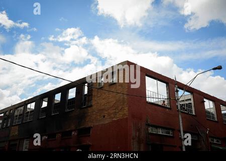 (150417) -- JOHANNESBURG, le 17 avril 2015 -- un homme se tient debout sur le toit d'un garage appartenant à des Nigérians où près de 20 véhicules ont été incendiés dans la ville de Johannesburg, en Afrique du Sud, le 17 avril 2015. Vendredi, la police sud-africaine a tiré des balles en caoutchouc pour disperser les émeutiers dans le centre de Johannesburg, un nouveau foyer de violence xénophobe. La vague actuelle de violence xénophobe touche principalement Durban et Johannesburg. Selon les chiffres officiels, cinq personnes ont été tuées et des milliers d'immigrants déplacés. (djj) AFRIQUE DU SUD-JOHANNESBURG-ATTAQUE XÉNOPHOBE ZhaixJianlan PUBLICATIONxNOTxINxCHN JO Banque D'Images