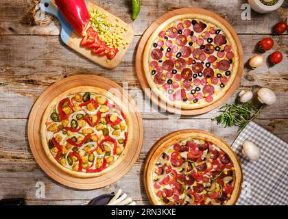 pizza photo shoot avec des plans de dessus et de côté pizza sur planche de bois. Prise de vue descendante, arrière-plan appétissant. peu de pizzas en arrière-plan. bois. Banque D'Images