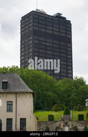 Un grand immeuble de bureaux en verre noir au cœur de Bruxelles, Belgique. Sur la forground une maison ancienne, faite de pierre. Banque D'Images