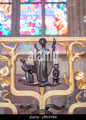 Détail d'une sculpture de Sainte Ludmila sur la porte de sa chapelle à l'intérieur de la cathédrale Saint-Guy. Il la dépeint en train de faire une corvée domestique, dans ce cas, filer. Banque D'Images