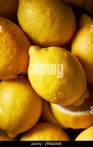 Photo vue de dessus de nombreux citrons remplissant le tir. Couleur jaune vif à contraste élevé. Belle texture des agrumes. Image verticale. Banque D'Images