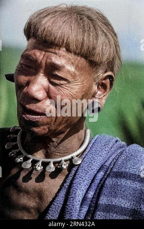 A man of the Konyak Naga tribe, with plugs distorting his ears and a necklace indicating the number of heads he has cut off. Photograph possibly by Ch Stock Photo