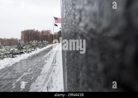 WASHINGTON DC, États-Unis — le mémorial des anciens combattants de la guerre de Corée à Washington DC couvert de neige pendant l'hiver. Le mémorial, situé sur le National Mall, rend hommage aux vétérans de la guerre de Corée avec 19 statues en acier inoxydable représentant des soldats en patrouille. La neige ajoute une atmosphère sereine et réfléchissante au site historique, rehaussant l'hommage solennel aux soldats. Banque D'Images