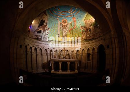 WASHINGTON, DC, États-Unis — Une mosaïque détaillée représentant la Résurrection de Jésus-Christ orne le plafond en demi-dôme au-dessus de l'autel dans la chapelle de la Résurrection de la cathédrale nationale de Washington, DC. La chapelle, construite dans le style normand, présente des espaces intimes avec des arches semi-circulaires et des plafonds inférieurs. Cette mosaïque, créée par l'artiste Hildreth Meirère, fait partie d'une série illustrant les apparitions post-Résurrection de Jésus, avec des mosaïques supplémentaires conçues par Rowan et Irene LeCompte sur les parois latérales. Banque D'Images