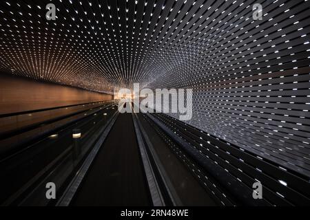 Installation lumineuse Multiverse de la National Gallery of Art Washington D.C. // WASHINGTON D.C. (États-Unis) — L'installation lumineuse Multiverse de l'artiste Leo Villareal illumine la passerelle mobile entre les bâtiments est et Ouest de la National Gallery of Art. Cette œuvre d'art immersive présente des milliers de lumières LED créant des motifs dynamiques, offrant aux visiteurs un voyage fascinant à travers un tunnel de lumière en constante évolution. Banque D'Images