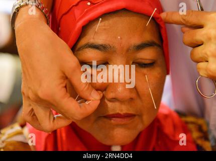 (150518) -- BEIJING, 18 mai 2015 -- la photo prise le 30 novembre 2012 montre un membre de l'UMNO (United Malays National Organization) recevant un traitement d'acupuncture à Kuala Lumpur, capitale de la Malaisie. L'acupuncture et la moxibustion sont des formes de médecine traditionnelle chinoise largement pratiquées en Chine et également présentes dans les régions du sud-est asiatique, en Europe et dans les Amériques. Ils sont parmi les thérapies chinoises les plus largement pratiquées dans le pays et gagnent en popularité en Occident. Les théories de l'acupuncture et de la moxibustion soutiennent que le corps humain agit comme un petit univers connecté par ch Banque D'Images