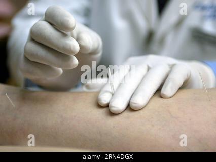 (150518) -- PÉKIN, 18 mai 2015 -- une photo prise le 27 juin 2003 montre un médecin chinois Tian Xiaoming insérant des aiguilles sur des points d'acupuncture d'une jambe d'un patient arthritique dans un traitement au Bethesda acupuncture Treatment Center dans l'État du Maryland, aux États-Unis. L'acupuncture et la moxibustion sont des formes de médecine traditionnelle chinoise largement pratiquées en Chine et également présentes dans les régions du sud-est asiatique, en Europe et dans les Amériques. Ils sont parmi les thérapies chinoises les plus largement pratiquées dans le pays et gagnent en popularité en Occident. Les théories de l'acupuncture Banque D'Images