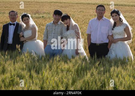 (150519) -- HUAIAN, 19 mai 2015 -- des couples posent pour des photos de mariage dans le champ de blé du comté de Xuyi, dans la province du Jiangsu de l'est de la Chine, le 19 mai 2015. Quelques nouveaux couples d'une entreprise d'alimentation électrique se sont réunis dans un champ de blé pour prendre des photos de mariage de groupe avant leurs mariages. Beaucoup de couples choisissent de se marier le 20 mai de ces années, car la prononciation de 520 sonne comme je t'aime en chinois.) (mt) CHINA-JIANGSU-HUAIAN-PHOTO DE MARIAGE (CN) ZhouxHaijun PUBLICATIONxNOTxINxCHN 150519 Huaian Mai 19 2015 couples posent pour des photos de mariage dans le champ de blé dans le comté de Xuyi est Chine S Jiangsu province M Banque D'Images