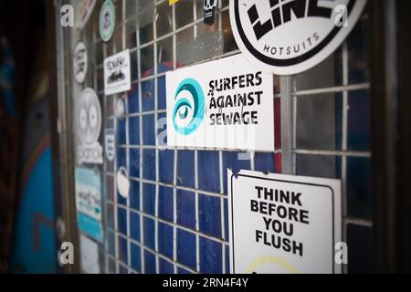 Signes sur la vitrine de la boutique de Steve Crawford, le propriétaire de la boutique de surf Fluid concept à Scarborough, dans le nord du Yorkshire. Steve possède la boutique depuis 17 ans Banque D'Images