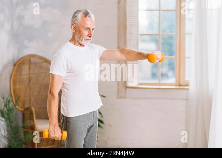 Faites de l'exercice avec des haltères orange à la maison Banque D'Images