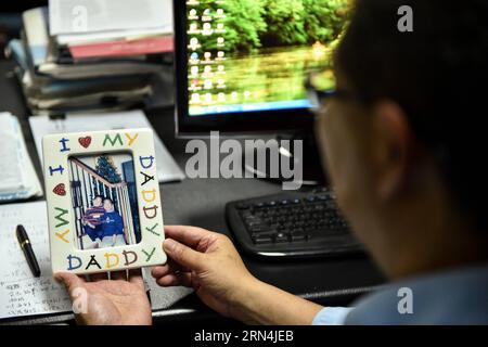 (150522) -- PÉKIN, le 22 mai 2015 -- lu Xianping regarde la photo de ses fils à Shenzhen Chipscreen Biosciences Ltd. À Shenzhen, dans la province du Guangdong du sud de la Chine, le 20 mai 2015. Lu Xianping, avec quatre autres scientifiques étrangers de retour, a passé 14 ans à développer Chidamide, le premier inhibiteur oral de HDAC au monde, qui a reçu l approbation réglementaire en janvier. (zkr) CHINA-SHENZHEN-LU XIANPING-PHARMACEUTICAL RESEARCH (CN) MaoxSiqian PUBLICATIONxNOTxINxCHN 150522 Pékin Mai 22 2015 lu Xianping regarde la photo de ses fils À Shenzhen Biosciences Ltd à Shenzhen South China S Gua Banque D'Images