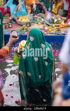 Le dévot priant avec des offrandes religieuses pour le dieu du soleil dans le festival Chhath Banque D'Images