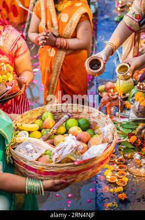 Le dévot priant avec des offrandes religieuses pour le dieu du soleil dans le festival Chhath Banque D'Images