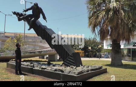 (150530) -- ATHÈNES, photo prise le 14 mai 2015 montre l'artiste autodidacte grec de 22 ans Tasos Nyfadopoulos debout devant sa crise de sculpture à Athènes, capitale de la Grèce. Située à côté de l’avenue Vouliagmenis, à quelques kilomètres du centre d’Athènes, l’impressionnante sculpture, d’environ 7 mètres de long et 4 mètres de haut, est un indice boursier géant qui s’est écrasé sur le sol et s’est brisé en morceaux. Sur le dessus, un homme est sur le point de tomber alors que l'indice s'effondre. ) GRÈCE-ATHÈNES-SCULPTURE- CRISE AthanasiaxBatziou PUBLICATIONxNOTxINxCHN 150530 Athènes la photo prise LE 14 2015 mai montre 22 année Banque D'Images