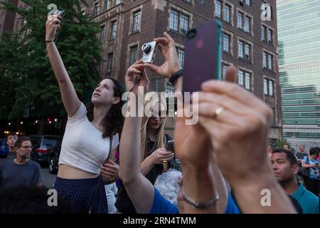 (150531) -- NEW YORK, 30 mai 2015 -- les gens attendent de prendre des photos de Manhattanhenge à Manhattan, New York, États-Unis, le 30 mai 2015. Les touristes, les résidents et les navetteurs ont attendu pour prendre des photos de l'effet connu sous le nom de Manhattanhenge, mais ont été contrecarrés par les nuages samedi. Le Manhattanhenge se réfère à la circonstance deux fois par an pendant laquelle le soleil couchant s'aligne précisément avec les rues est-ouest de l'arrondissement de New York City de Manhattan. U.S.-NEW YORK-MANHATTANHENGE LixMuzi PUBLICATIONxNOTxINxCHN 150531 New York Mai 30 2015 célébrités attendent de prendre des photos de Manhattanhenge en T. Banque D'Images