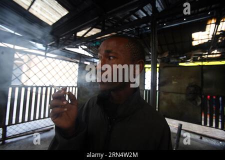 (150601) --NAIROBI, le 31 mai 2015 --un homme fume une cigarette dans une zone réservée aux fumeurs du quartier central des affaires de Nairobi au Kenya, le 31 mai 2015. La Journée mondiale sans tabac est célébrée pour mettre en lumière les risques sanitaires associés au tabagisme et plaider en faveur de politiques efficaces pour réduire la consommation de tabac. John Okoyo) (zjy) KENYA-NAIROBI-WORLD NO TOBACCO DAY SunxRuibo PUBLICATIONxNOTxINxCHN Nairobi 31 2015 mai un homme fume une cigarette DANS une zone fumeurs désignée dans le quartier central des affaires de Nairobi au Kenya LE 31 2015 mai, la Journée mondiale sans tabac EST marquée pour souligner le Banque D'Images