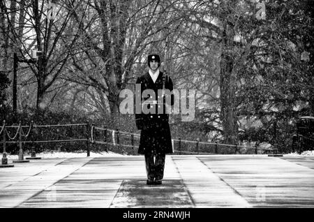 Un soldat monte la garde dans la neige qui tombe sur le tombeau de l'inconnu au cimetière national d'Arlington dans la neige. Le garde s'engage dans un jeu de routine dans laquelle il marches 21 marches à descendre le mat noir derrière le tombeau, tourne, fait face à l'est pour 21 secondes, se retourne et fait face au nord pendant 21 secondes, puis prend 21 pas en bas de la mat et répète le processus. Banque D'Images