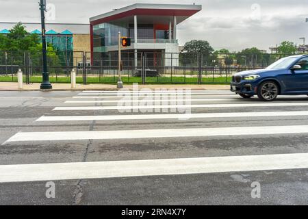 San Antonio, Texas, États-Unis – 9 mai 2023 : une voiture à grande vitesse entre dans un passage piéton zèbre dans une rue de la ville de San Antonio, Texas. Banque D'Images