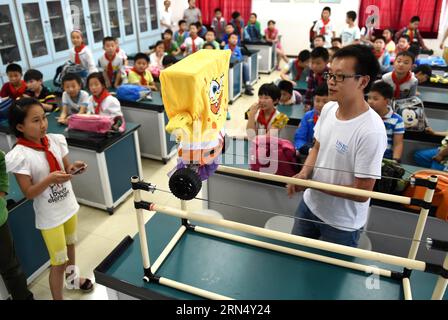 (150604) -- HEFEI, le 4 juin 2015 -- un élève contrôle un robot se déplaçant sur des câbles à l'école primaire Huafu Junyuan à Hefei, capitale de la province d'Anhui dans l'est de la Chine, le 4 juin 2015. Une équipe de robots de l'Université des sciences et technologies de Chine a été invitée à l'école pour faire la démonstration de leurs robots aux étudiants. (mp) CHINA-ANHUI-HEFEI-SCHOOL-ROBOT (CN) LiuxJunxi PUBLICATIONxNOTxINxCHN Hefei juin 4 2015 un élève contrôle un robot se déplaçant SUR des fils À l'école primaire Huafu Junyuan à Hefei capitale de la Chine orientale S Anhui province juin 4 2015 une équipe de robots de l'Université des Sciences et T Banque D'Images