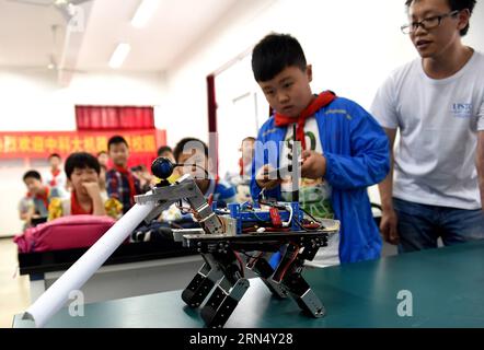 (150604) -- HEFEI, 4 juin 2015 -- un élève contrôle un robot qui transporte du journal à l'école primaire Huafu Junyuan à Hefei, capitale de la province d'Anhui de l'est de la Chine, le 4 juin 2015. Une équipe de robots de l'Université des sciences et technologies de Chine a été invitée à l'école pour faire la démonstration de leurs robots aux étudiants. (mp) CHINA-ANHUI-HEFEI-SCHOOL-ROBOT (CN) LiuxJunxi PUBLICATIONxNOTxINxCHN Hefei juin 4 2015 un élève contrôle un robot qui transporte le journal À l'école primaire Huafu Junyuan à Hefei capitale de la Chine orientale, province de S Anhui juin 4 2015 une équipe de robots de l'Université Banque D'Images