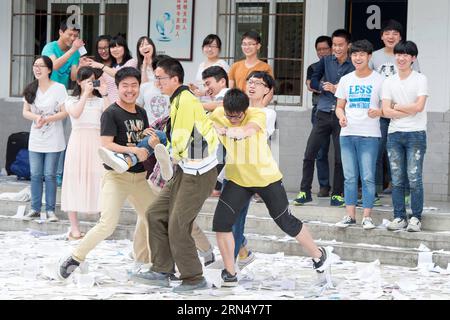 (150604) -- HEFEI, 4 juin 2015 -- des étudiants posent pour des photos après avoir terminé leur dernier cours à l'école d'éducation de Wanzhi, une école spéciale pour les candidats à la deuxième université, à Hefei, capitale de la province d'Anhui de l'est de la Chine, le 4 juin 2015, qui est également le dernier jour de cours avant les examens. Plus de 1 000 étudiants, qui vont passer les examens d'entrée au collège national pour la deuxième fois, ont été étudiés ici pendant une année entière, répétant le cycle de la vie d'étude de tôt le matin à la nuit. Ces candidats qui viennent pour la deuxième fois ne prennent qu'un jour de congé par mois. Examen d'entrée au collège national de Chine Banque D'Images