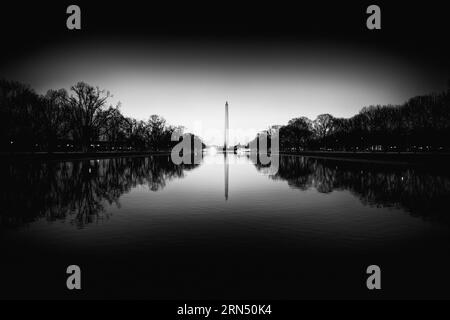 WASHINGTON, DC--la lumière avant l'aube se reflète sur les eaux calmes du Lincoln Memorial Reflecting Pool, avec le Washington Monument au centre du cadre. Banque D'Images