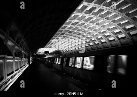 WASHINGTON DC, États-Unis — Une photographie en noir et blanc d'une station de métro de Washington DC, représentant l'un des principaux centres de transport desservant la capitale nationale. Le réseau métropolitain joue un rôle essentiel dans le transport quotidien de milliers de personnes, reliant les quartiers, les quartiers d'affaires et les points d'intérêt. Banque D'Images