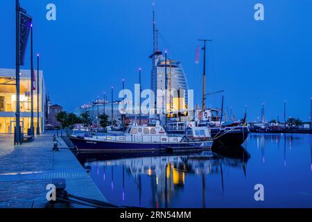 Navires historiques dans le nouveau port avec l'Atlantic Sail City Hotel au crépuscule, Bremerhaven, estuaire Weser, Weser, côte de la mer du Nord, Land Brême, Allemagne Banque D'Images