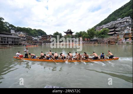 (150616) -- FENGHUANG, le 16 juin 2015 -- les gens rament sur un bateau-dragon sur la rivière Tuojiang dans le comté de Fenghuang, province du Hunan au centre de la Chine, le 16 juin 2015. Les équipes locales de bateaux-dragons se sont préparées pour la prochaine compétition célébrant le Dragon Boat Festival. Le Festival des bateaux-dragons, également connu sous le nom de Duanwu, est célébré chaque année le cinquième jour du cinquième mois du calendrier lunaire chinois, qui tombe le 20 juin de cette année. (zkr) CHINA-FENGHUANG-DRAGON BOAT(CN) LongxHongtao PUBLICATIONxNOTxINxCHN Fenghuang juin 16 2015 célébrités Row SUR un bateau dragon SUR LA rivière Tuojiang dans le comté de Fenghuang cent Banque D'Images