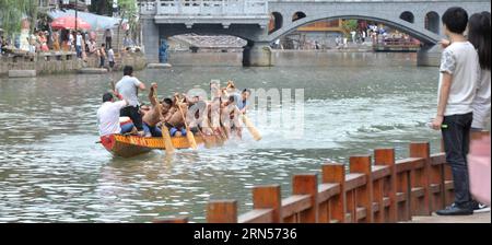 (150616) -- FENGHUANG, le 16 juin 2015 -- des gens regardent un bateau-dragon ramer sur la rivière Tuojiang dans le comté de Fenghuang, province du Hunan au centre de la Chine, le 16 juin 2015. Les équipes locales de bateaux-dragons se sont préparées pour la prochaine compétition célébrant le Dragon Boat Festival. Le Festival des bateaux-dragons, également connu sous le nom de Duanwu, est célébré chaque année le cinquième jour du cinquième mois du calendrier lunaire chinois, qui tombe le 20 juin de cette année.) (zkr) CHINA-FENGHUANG-DRAGON BOAT(CN) LongxHongtao PUBLICATIONxNOTxINxCHN Fenghuang juin 16 2015 célébrités Regardez un bateau Dragon ramant SUR LA rivière Tuojiang à Fenghuang Banque D'Images