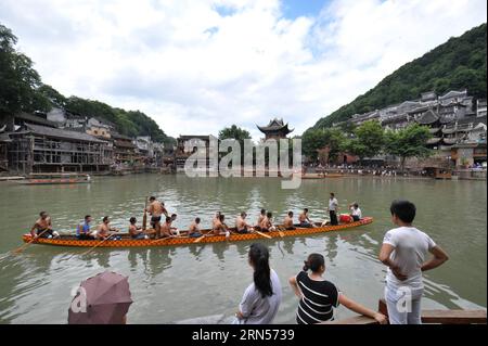 (150616) -- FENGHUANG, le 16 juin 2015 -- des gens regardent un bateau-dragon ramer sur la rivière Tuojiang dans le comté de Fenghuang, province du Hunan au centre de la Chine, le 16 juin 2015. Les équipes locales de bateaux-dragons se sont préparées pour la prochaine compétition célébrant le Dragon Boat Festival. Le Festival des bateaux-dragons, également connu sous le nom de Duanwu, est célébré chaque année le cinquième jour du cinquième mois du calendrier lunaire chinois, qui tombe le 20 juin de cette année. (zkr) CHINA-FENGHUANG-DRAGON BOAT(CN) LongxHongtao PUBLICATIONxNOTxINxCHN Fenghuang juin 16 2015 célébrités Regardez un bateau Dragon ramant SUR LA rivière Tuojiang à Fenghuang Banque D'Images