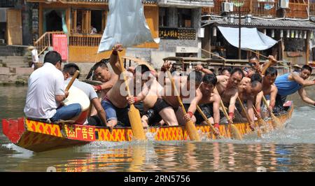 (150616) -- FENGHUANG, le 16 juin 2015 -- les gens rament sur un bateau-dragon sur la rivière Tuojiang dans le comté de Fenghuang, province du Hunan au centre de la Chine, le 16 juin 2015. Les équipes locales de bateaux-dragons se sont préparées pour la prochaine compétition célébrant le Dragon Boat Festival. Le Festival des bateaux-dragons, également connu sous le nom de Duanwu, est célébré chaque année le cinquième jour du cinquième mois du calendrier lunaire chinois, qui tombe le 20 juin de cette année.) (zkr) CHINA-FENGHUANG-DRAGON BOAT(CN) LongxHongtao PUBLICATIONxNOTxINxCHN Fenghuang juin 16 2015 célébrités Row SUR un bateau dragon SUR LA rivière Tuojiang dans le comté de Fenghuang Centr Banque D'Images