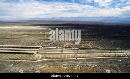 (150623) -- URUMQI, 23 juin 2015 -- une photo prise avec un drone le 19 mai 2015 montre un train à grande vitesse qui sort de la gare nord de Turpan, dans la région autonome ouïgour du Xinjiang, au nord-ouest de la Chine. Le train à grande vitesse Lanxin, long de 1 776 kilomètres, a été mis en service le 26 décembre 2014, reliant Lanzhou, capitale de la province du Gansu, Xining, capitale de la province du Qinghai, et Urumqi, toutes situées dans le nord-ouest de la Chine. En 2015, des photos aériennes de la section du Xinjiang du train à grande vitesse de Lanxin ont été prises par un groupe de photographie aérienne de l'agence de presse Xinhua et diverses formes de relief du Xinjiang ont été enregistrées. (p Banque D'Images