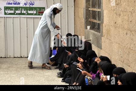 (150626) -- SANAA, 26 juin 2015 -- Un Yéménite distribue des cartes aux personnes qui attendent de recevoir de la nourriture dans un centre caritatif de Sanaa, au Yémen, le 26 juin 2015. Le bras humanitaire de l'ONU a annoncé jeudi qu'il fournirait une injection critique de financement d'urgence afin d'accélérer les efforts de secours aux civils pris au piège de la guerre au Yémen, où la querelle entre différentes fractions prépare une crise humanitaire. YÉMEN-SANAA-CRISE HUMANITAIRE HanixAli PUBLICATIONxNOTxINxCHN 150626 Sanaa juin 26 2015 un homme yéménite distribue des cartes pour des célébrités attendant de recevoir de la nourriture DANS un centre de charité à San Banque D'Images