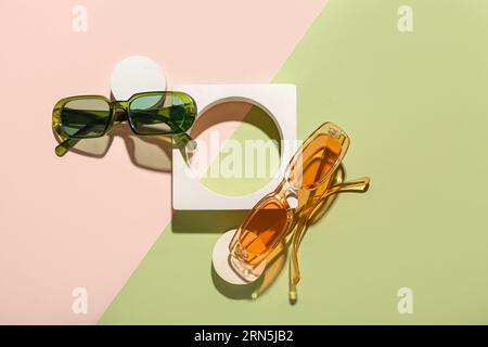Podiums décoratifs avec des lunettes de soleil élégantes sur fond coloré Banque D'Images