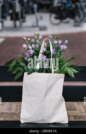 Sac à main en coton blanc avec de belles fleurs d'eustoma violettes Banque D'Images