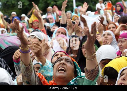 (150709) -- SRINAGAR, 9 juillet 2015 -- les dévots musulmans cachemiris lèvent la main pour demander des bénédictions alors qu'un prêtre en chef expose une relique du prophète Mahomet au sanctuaire Hazratbal, pour marquer le jour du martyr de Hazrat Ali pendant le Ramadan, à Srinagar, la capitale d'été du Cachemire contrôlé par les Indiens, le 9 juillet 2015. Les musulmans du monde entier s'abstiennent de manger, de boire et de fumer de l'aube au crépuscule pour observer le mois sacré de jeûne du Ramadan. KASHMIR-SRINAGAR-RAMADHAN JavedxDar PUBLICATIONxNOTxINxCHN 150709 Srinagar juillet 9 2015 les dévots musulmans cachemiris lèvent la main pour CHERCHER DES BÉNÉDICTIONS en H Banque D'Images