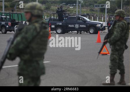 Des membres de la police fédérale et de la garde de l'armée mexicaine dans les environs du poste de péage Contepec de la route de l'Ouest à Michoacan, Mexique, le 12 juillet 2015. Joaquin El Chapo Guzman, le roi du cartel de la drogue mexicain, s'est évadé de prison par un tunnel de 1,5 km sous sa cellule, ont déclaré dimanche les autorités. Guzman, chef du cartel de la drogue de Sinaloa, a disparu samedi soir de la prison de haute sécurité Altiplano à l'extérieur de Mexico, selon la Commission de sécurité nationale. MEXIQUE-MICHOACAN-GUZMAN LOERA ArmandoxSolis PUBLICATIONxNOTxINxCHN membres de la police fédérale et de l'AR MEXICAINE Banque D'Images