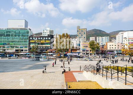 Parvis de la gare, immeubles de grande hauteur et magasins, montagnes derrière, Busan, province de Gyeongsangnam-do Banque D'Images