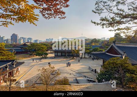 Palais de Changgyeonggung terrains, grands bâtiments et N Seoul Tower en arrière-plan, feuilles d'automne, lumière du soir, avec des touristes, Yongsan-gu, Séoul Banque D'Images